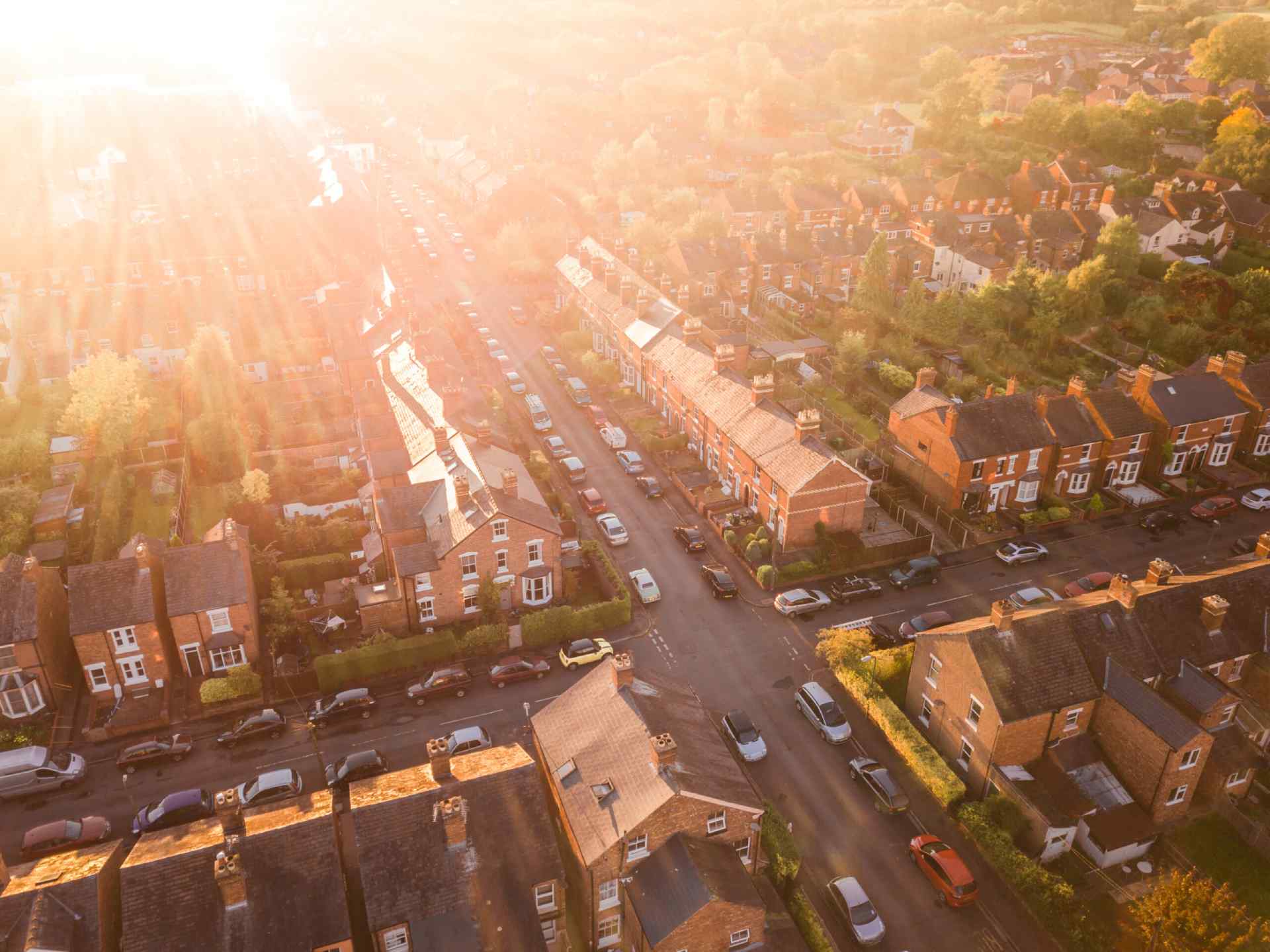 An aerial view of a traditional British residential area at sunset.