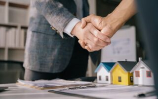 Two businessmen shake hands after agreeing on a leasehold extension.