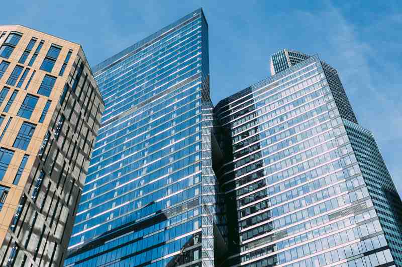 High rise commercial office buildings pictured on a sunny day.