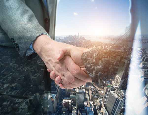 A commercial property landlord and tenant shake hands after negotiating a lease.