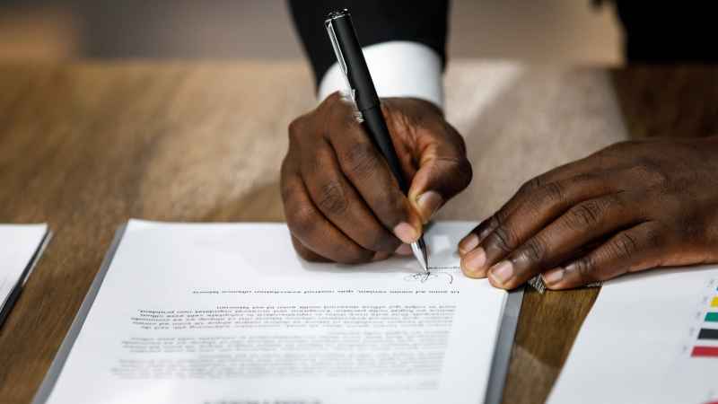 A closeup of an employer signing a reduction in pay notice.