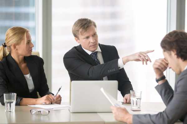 A manager tells an employee to leave the room during a meeting.