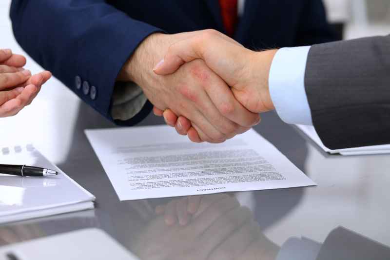 A solicitor shakes hands with a client after representing them at an employment tribunal