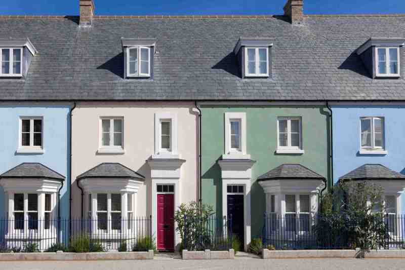 A row of colourful English terraced houses with a blue sky background.