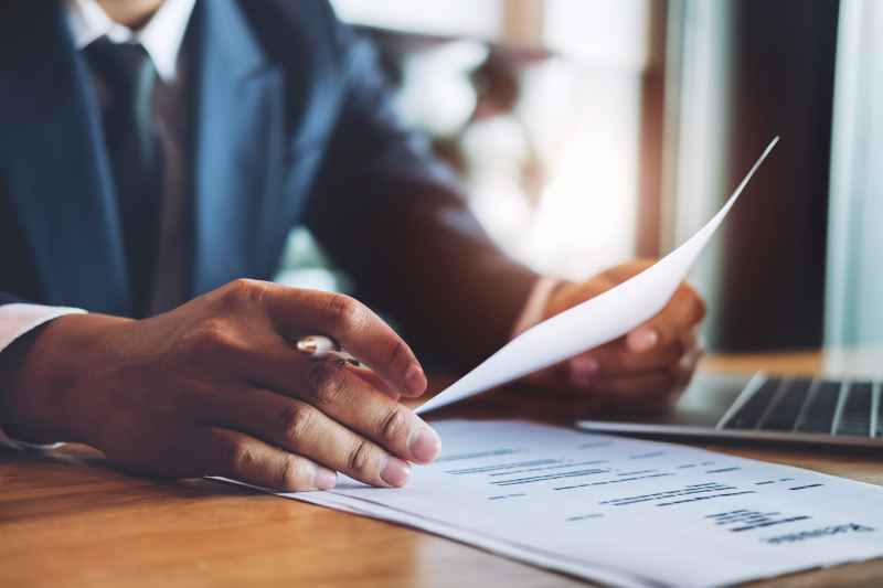 A solicitor sits at his desk and reviews a settlement agreement.