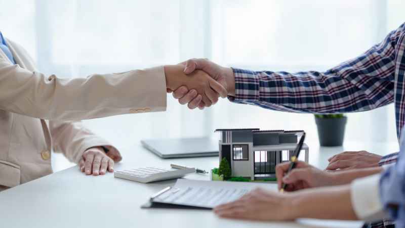 A client shakes hands with a property lawyer in a modern office