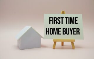 a small white house with a sign next to it that says first time home buyer